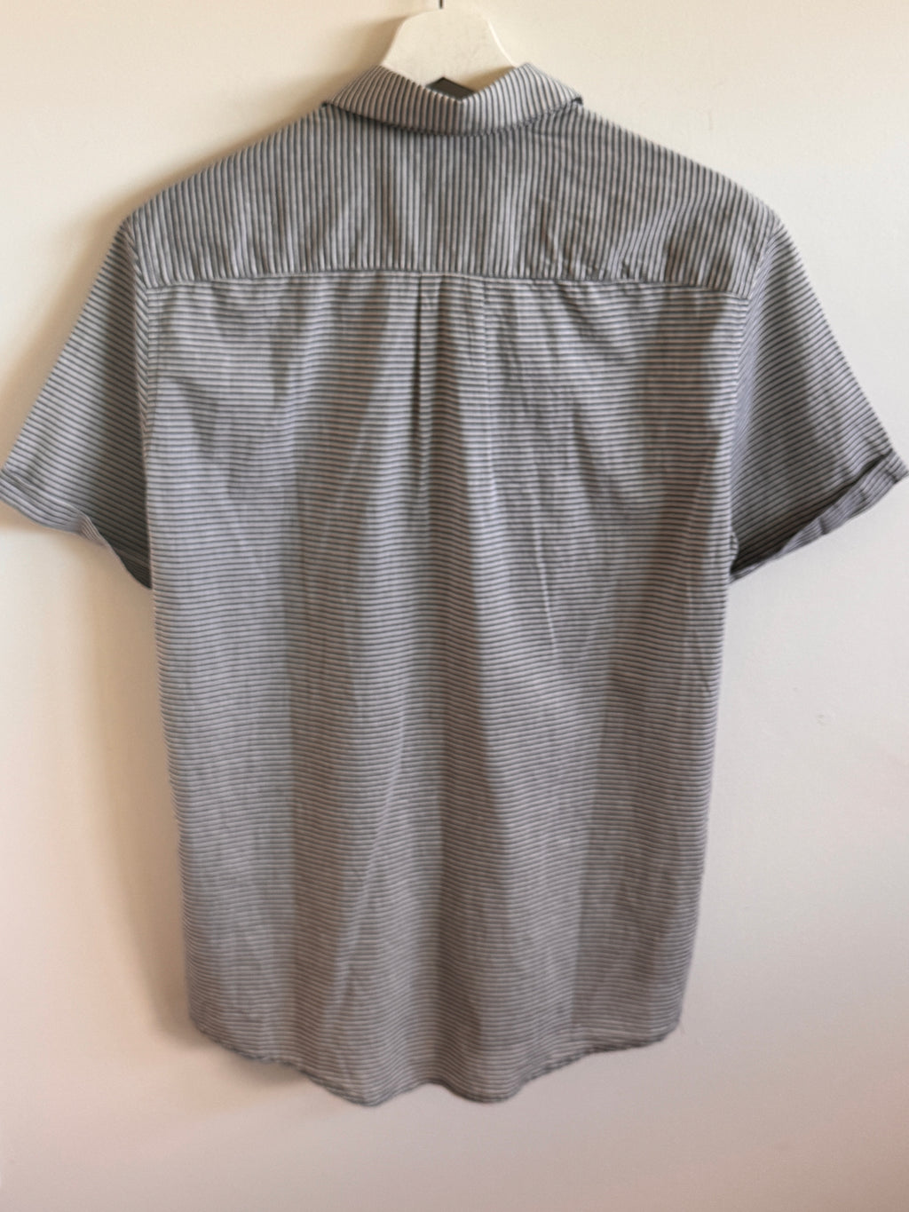 Short-sleeve shirt with a subtle pattern on a white background