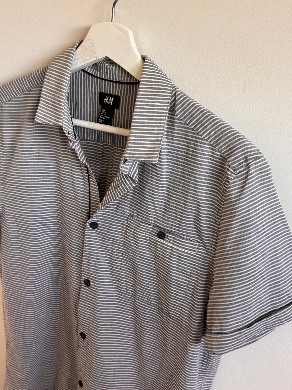 Striped shirt on a hanger with an H&M label.