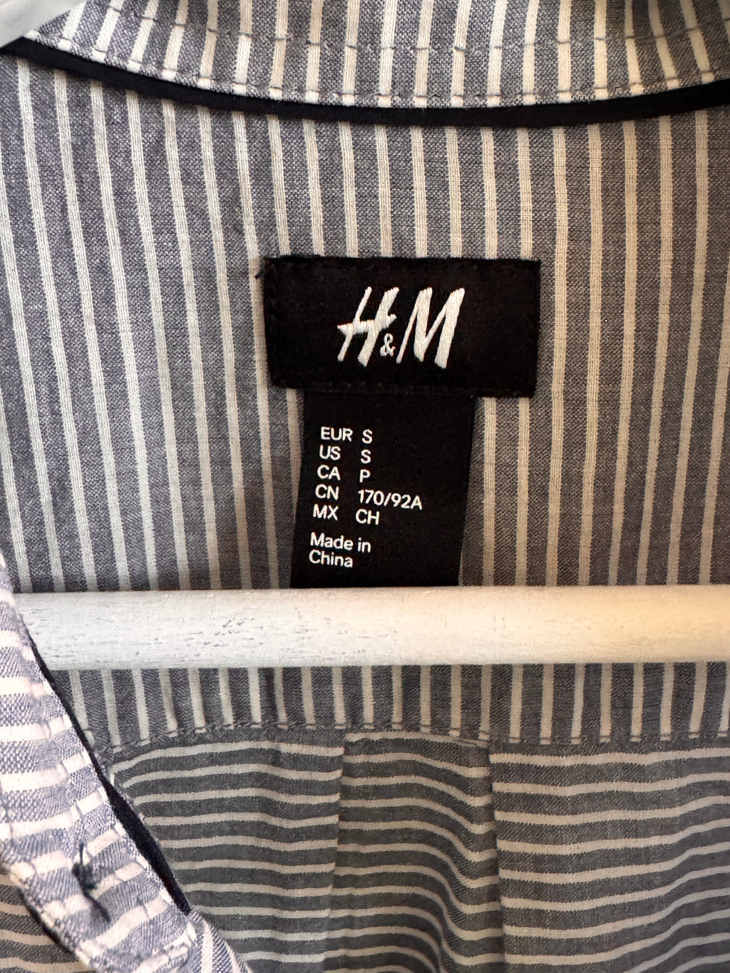 Close-up of an H&M label on a striped fabric background