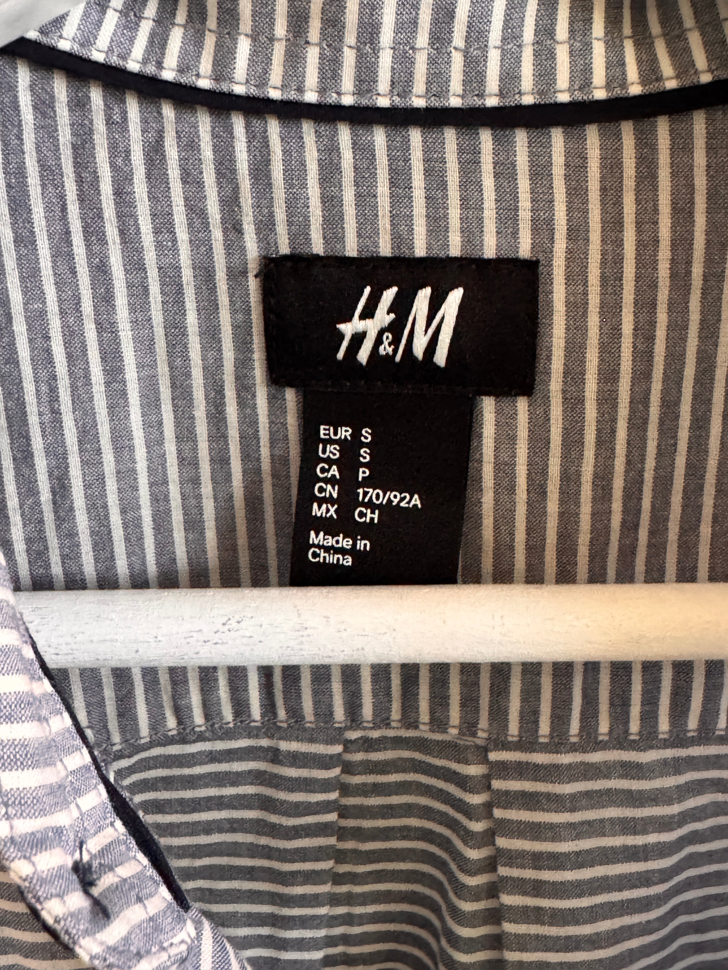 Close-up of an H&M label on a striped fabric background