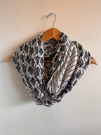 Black and white patterned fabric on a wooden hanger against a beige background