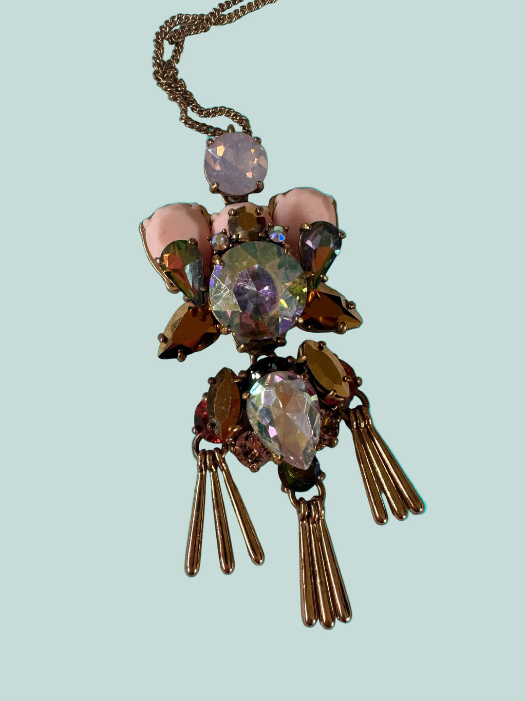 Decorative brooch style necklace with gemstones on a white background