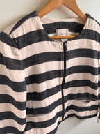 Black and white striped jacket on a hanger with a visible brand label.