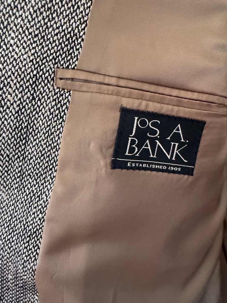 Close-up of a beige interior pocket lining with a black fabric brand label reading 'J.P.