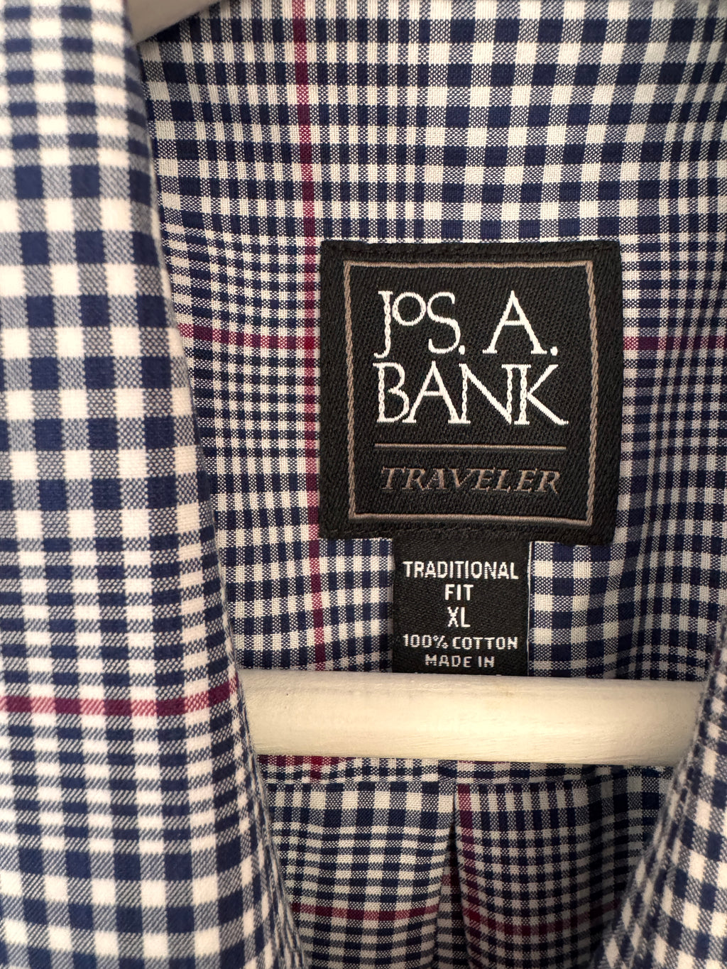 Close-up of a Jos. A. Bank Traveler shirt collar showing the navy, white, and red gingham pattern and the brand label.