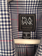 Close-up of a Jos. A. Bank Traveler shirt collar showing the navy, white, and red gingham pattern and the brand label.