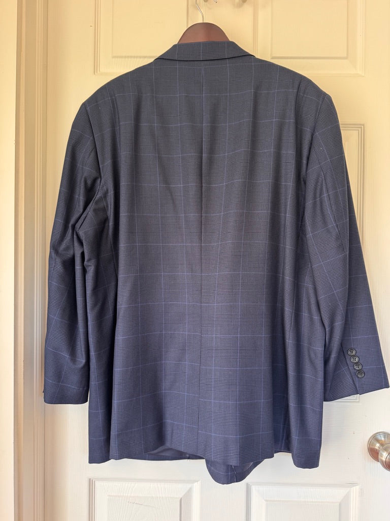 A navy blue windowpane plaid blazer jacket hanging on a wooden hanger against a cream-colored paneled door.