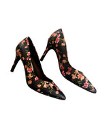 Black high-heeled shoes with floral pattern on a light background