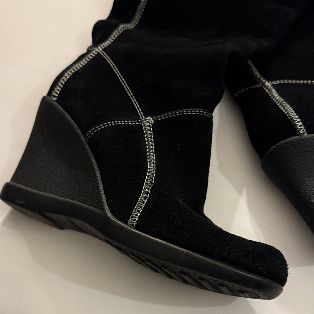 Black wedge shoe on a light background