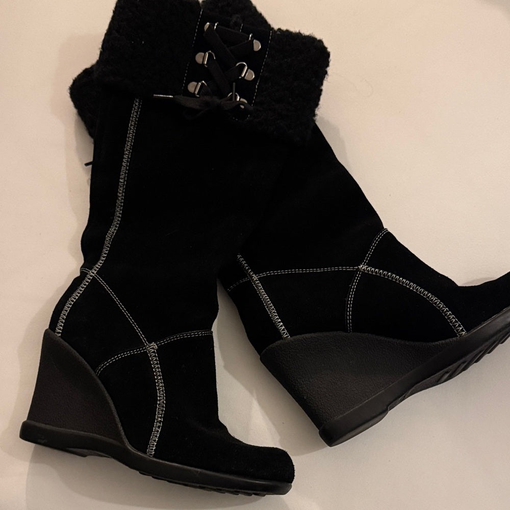 Black wedge boots with fur lining on a light background