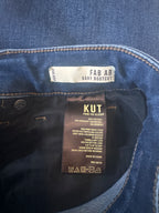 Close-up of denim fabric with brand labels on a dark background