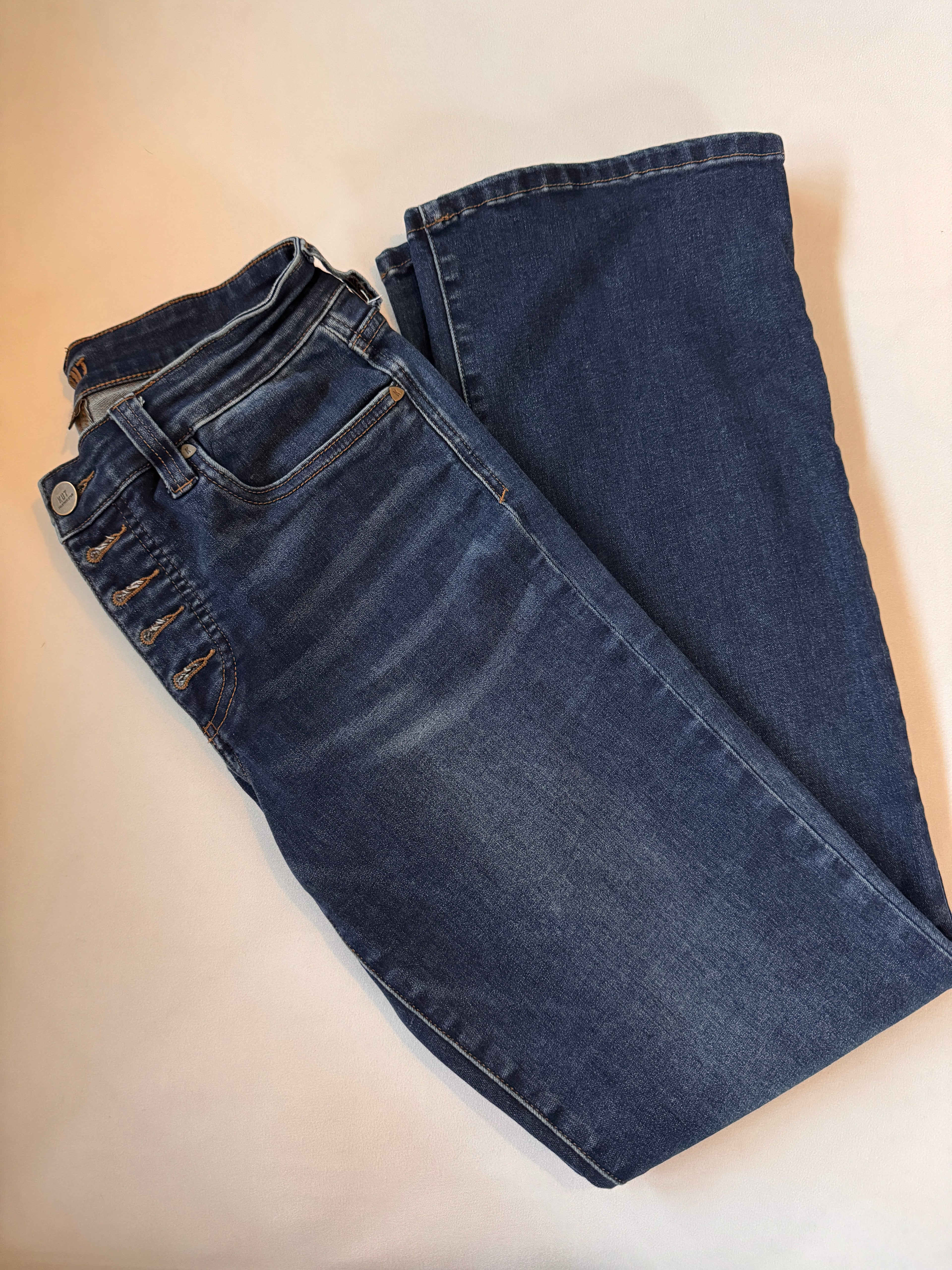 Folded pair of blue jeans on a beige background