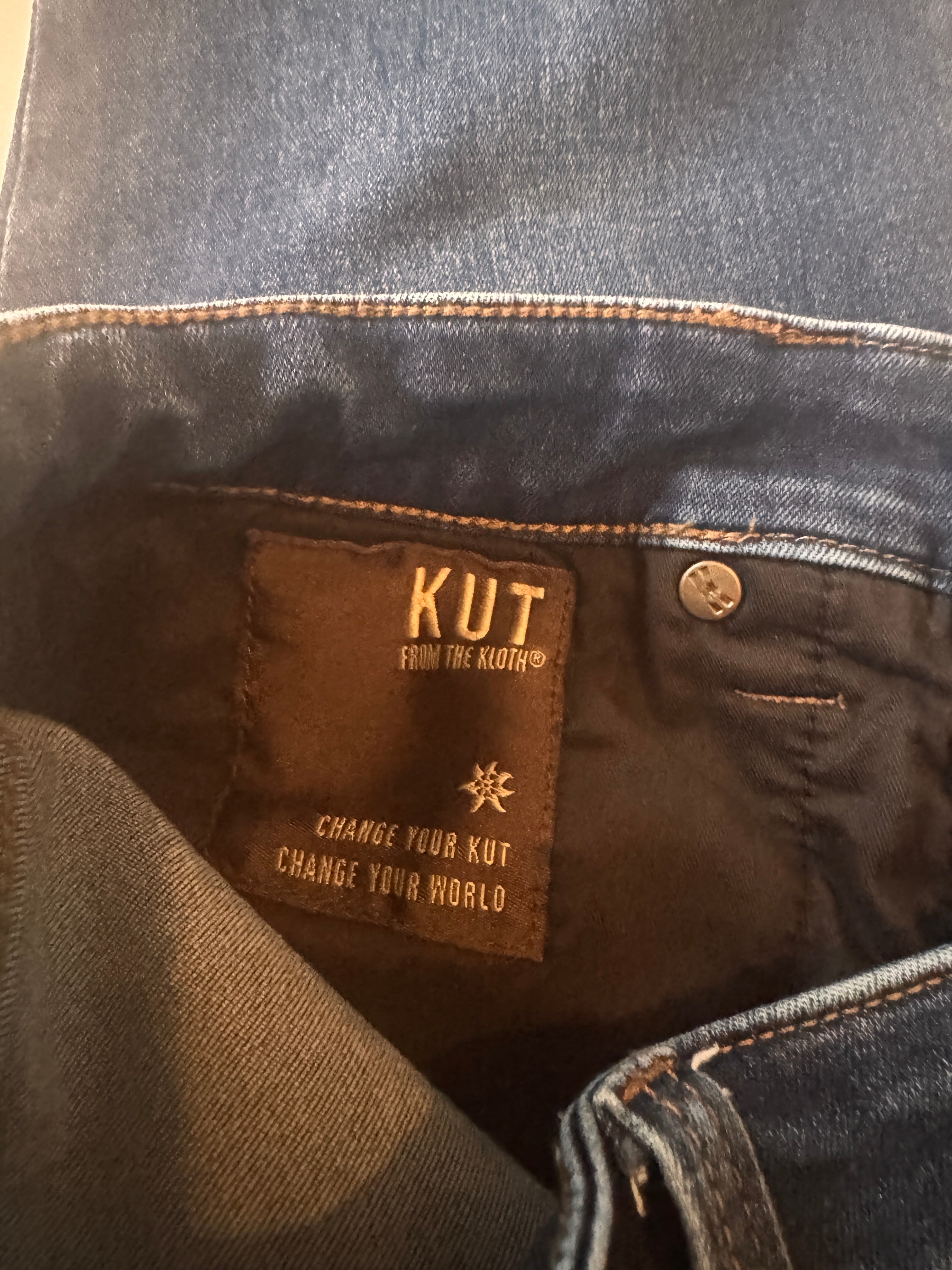 Close-up of a denim jacket with a 'KUT' brand label.