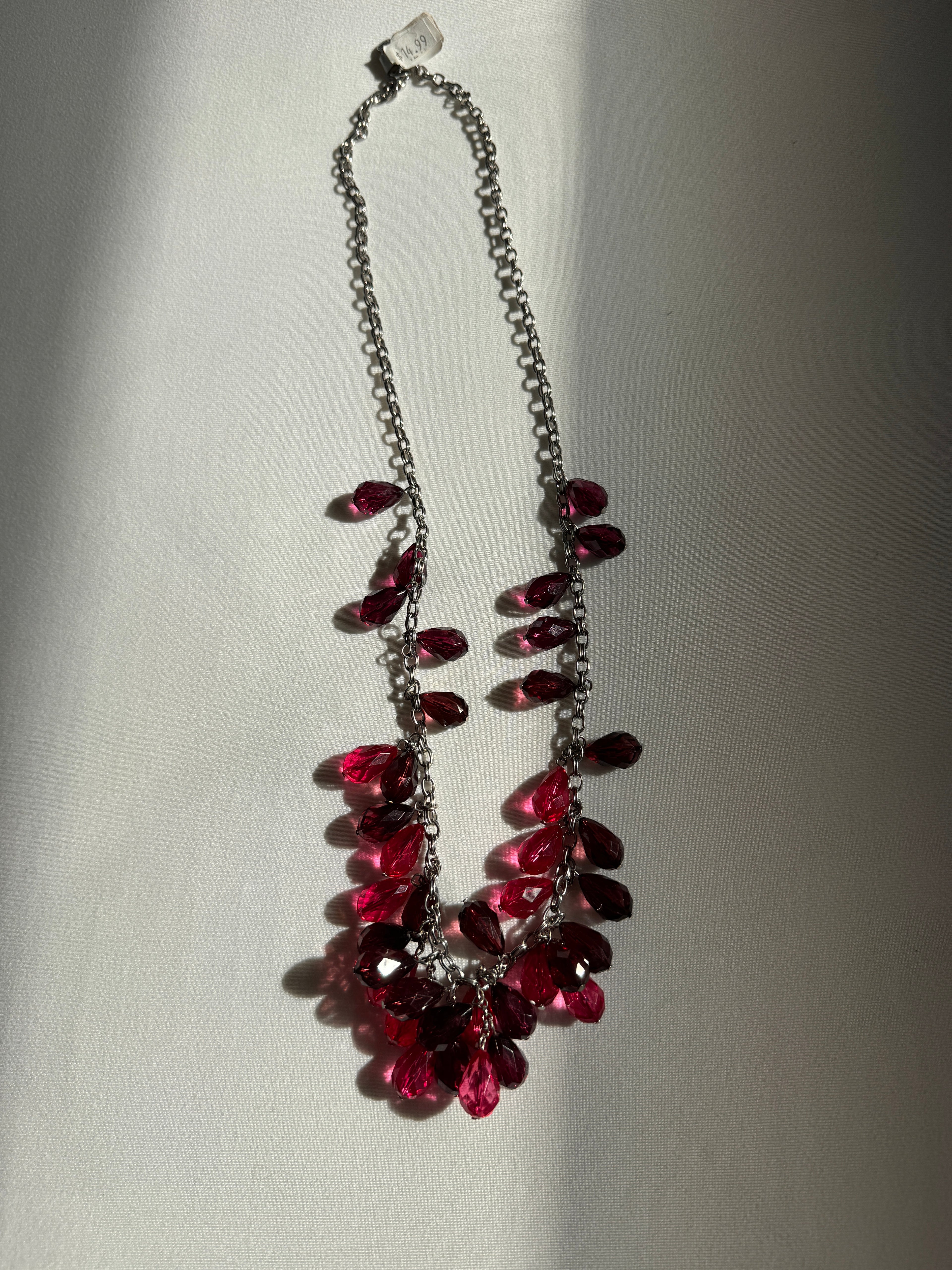 Necklace with red gemstones on a light gray background
