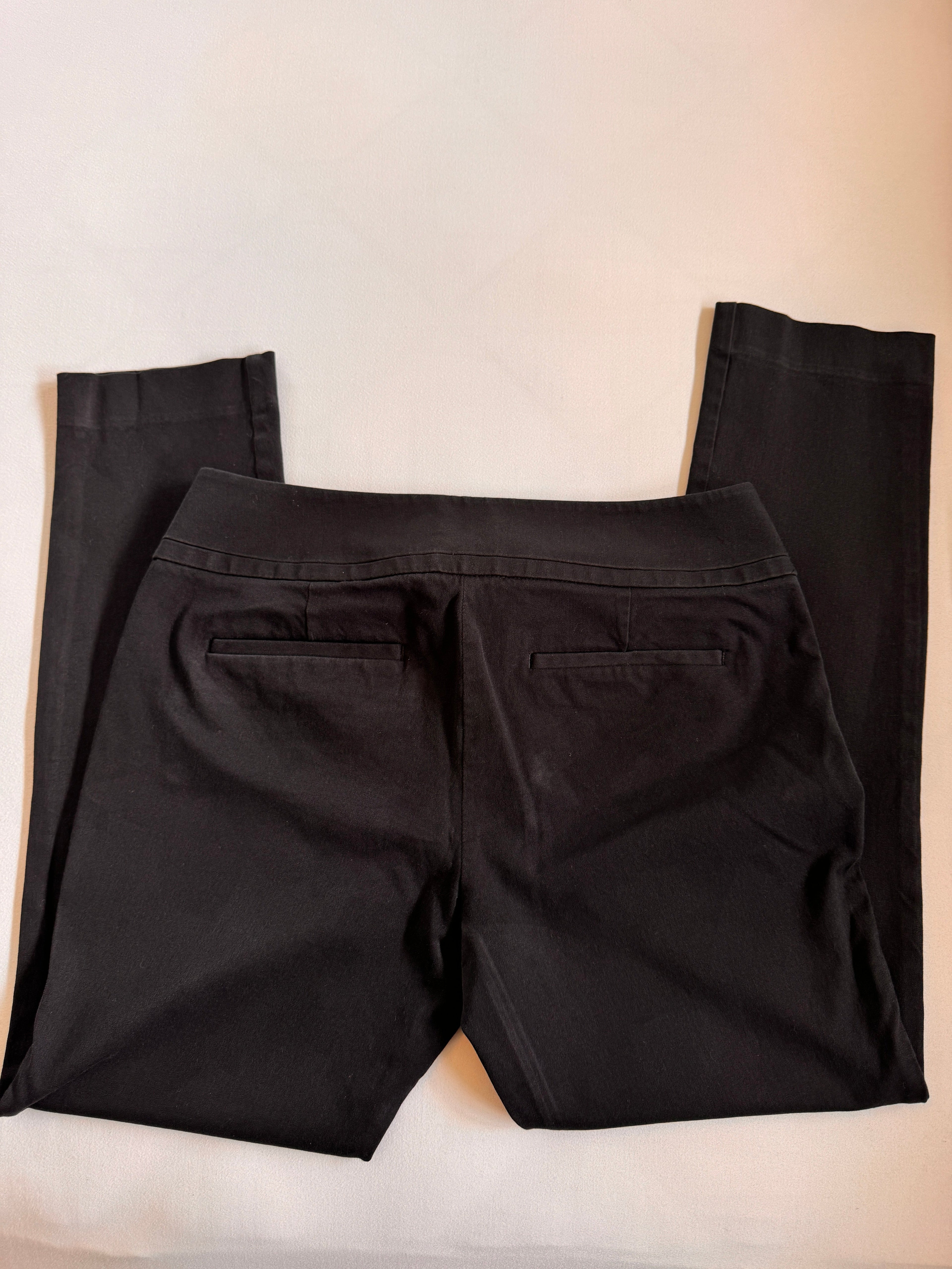 Folded black pants on a beige background