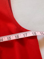 Red fabric with a measuring tape showing measurements on a white background