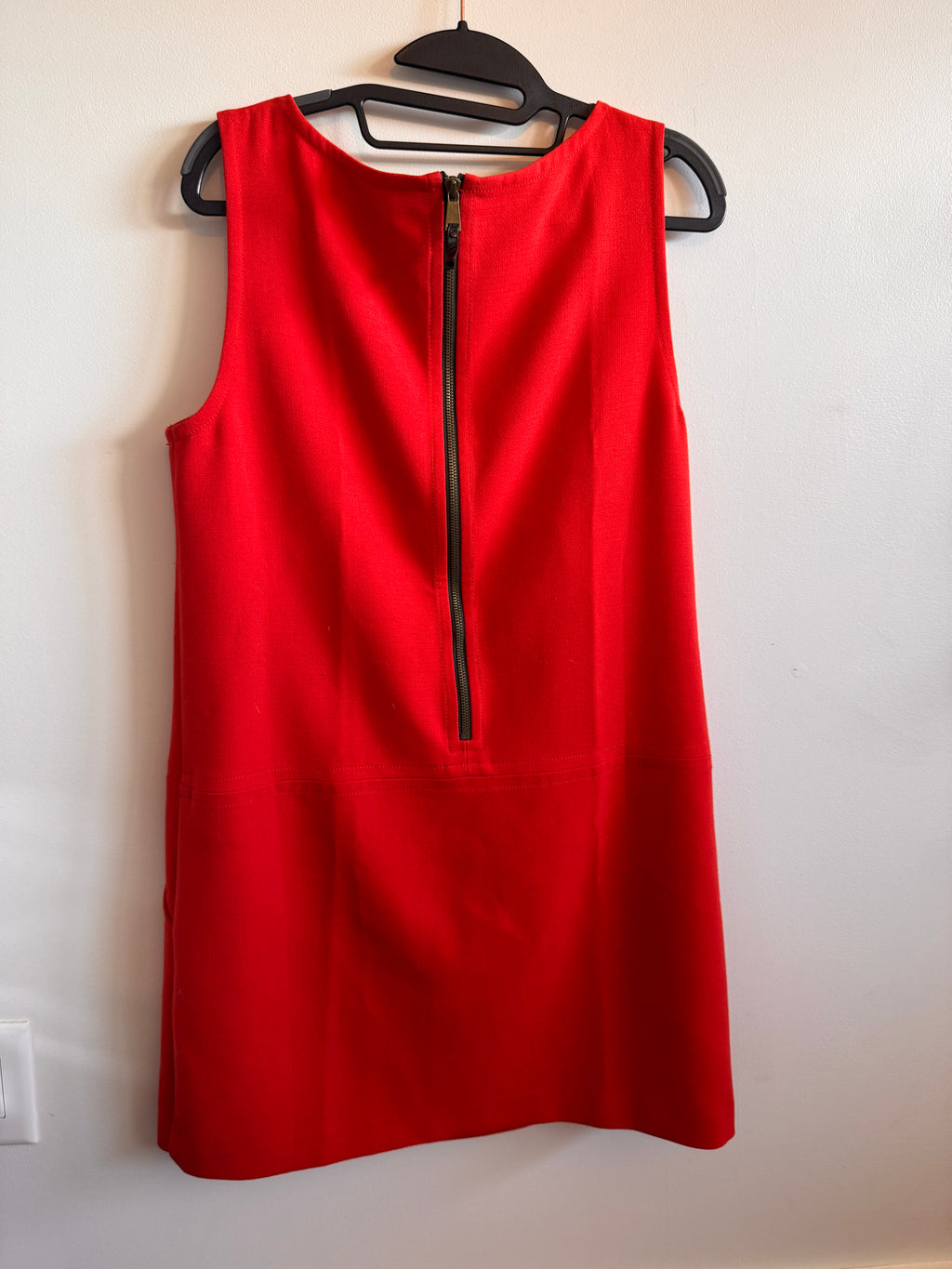 Red dress on a hanger against a white background
