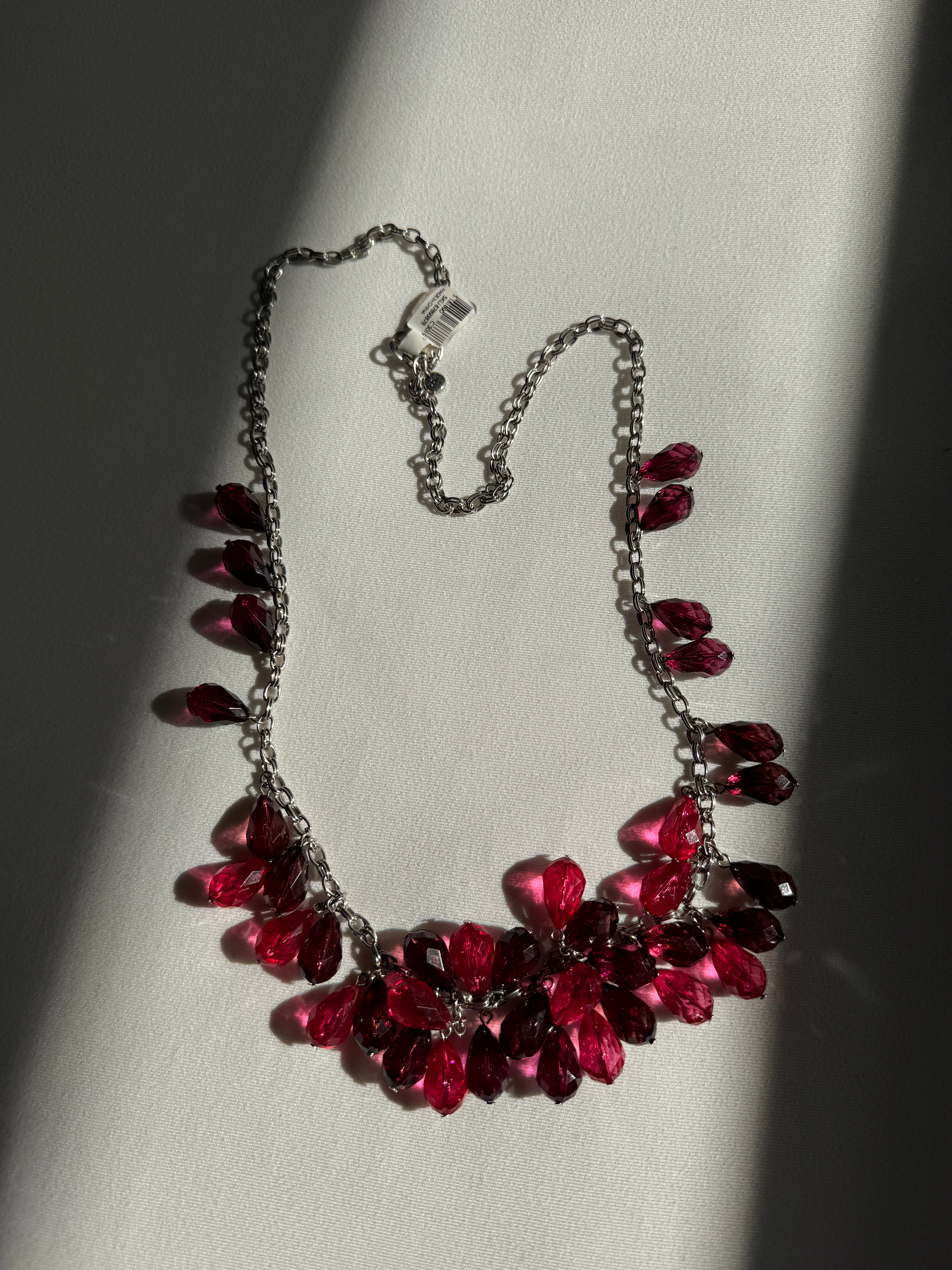Necklace with red and purple beads on a light background
