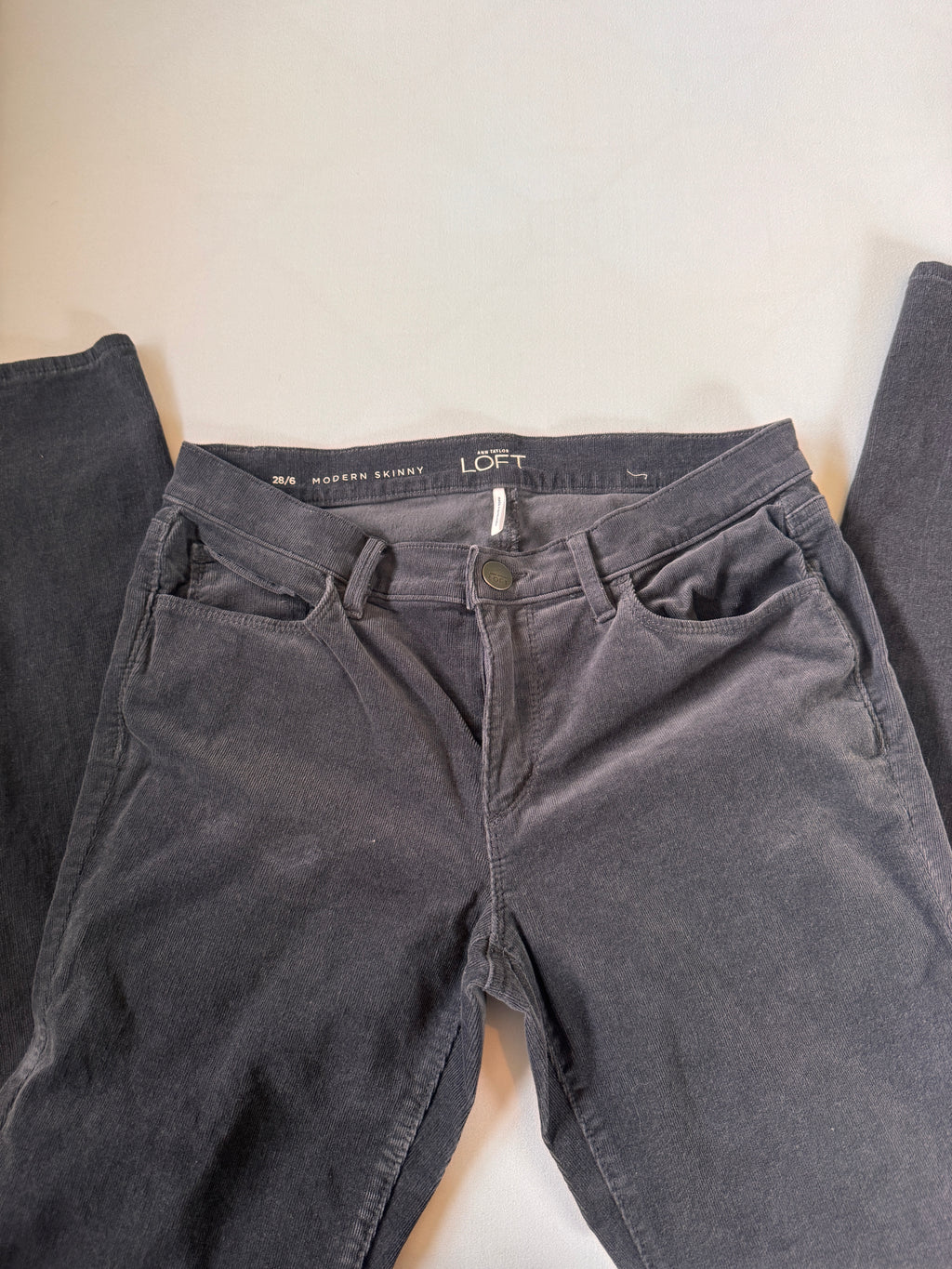 Dark gray pants with brand label on a light background