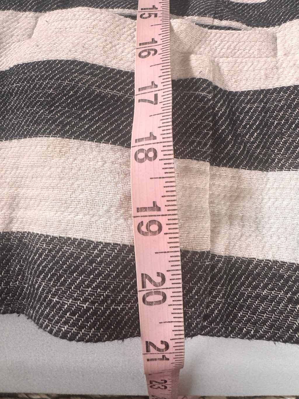 Fabric with a measuring tape showing measurements on a striped background