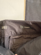 Folded black pants on a beige background