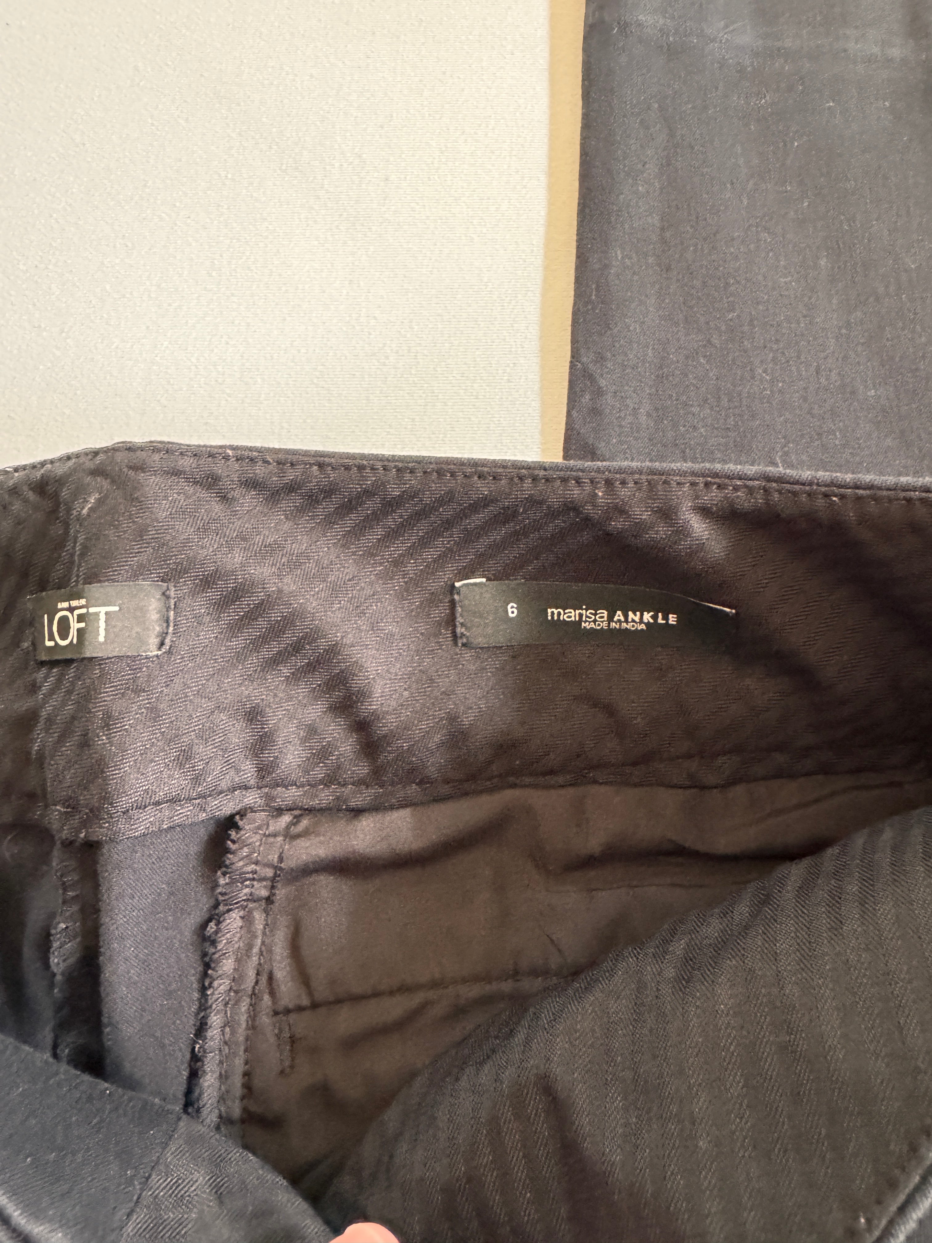 Folded black pants on a beige background