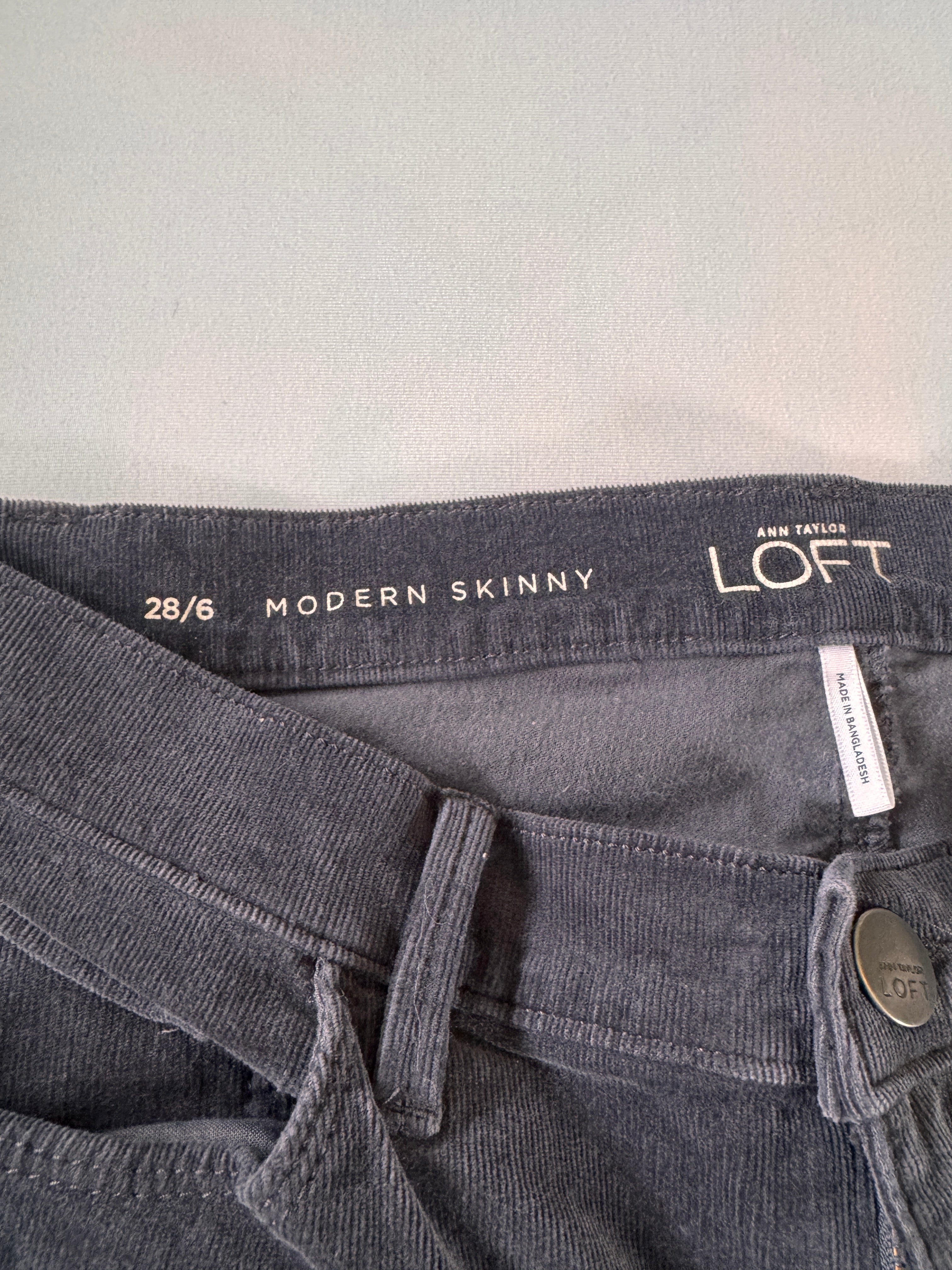 Gray jeans with 'Loft' branding and size information on a light gray background