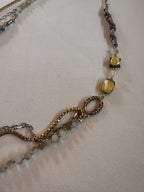 Close-up of a necklace with gold and silver chains on a light fabric background