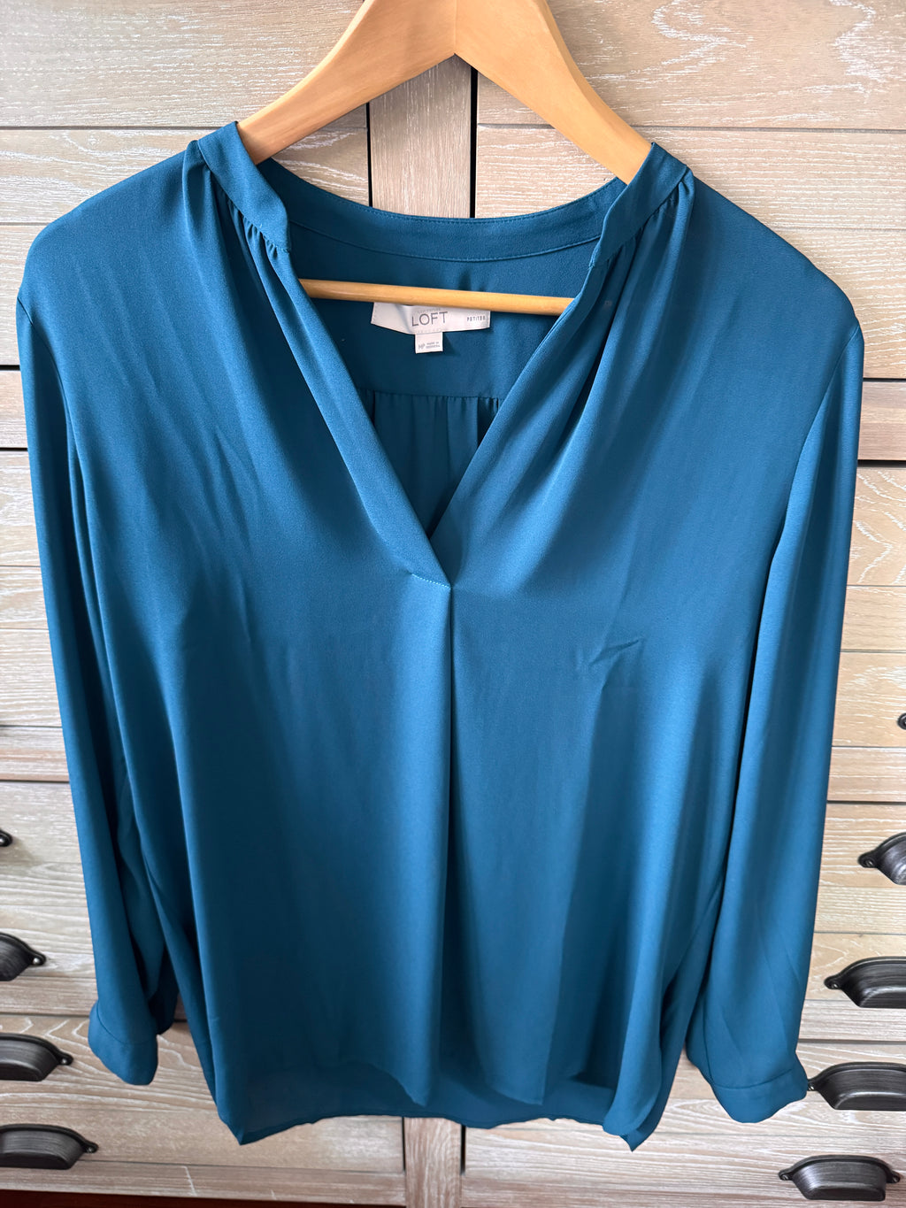 Blue dress on a wooden hanger against a wooden floor background