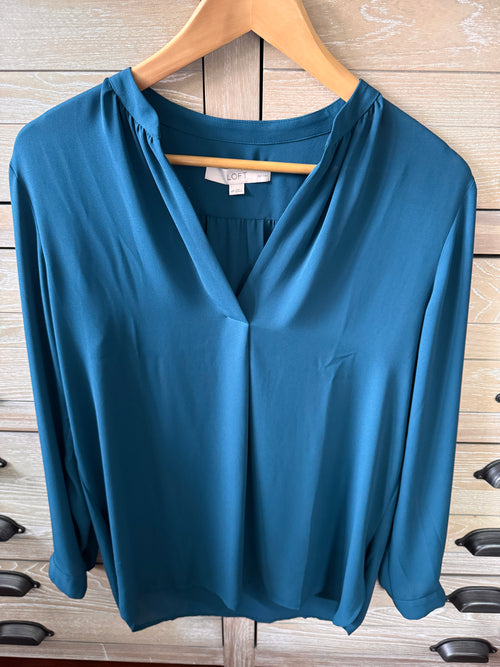 Blue dress on a wooden hanger against a wooden floor background