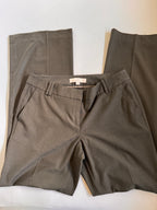 Greige pants with a visible brand tag on a white surface
