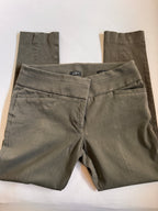 Folded olive green pants with a brand label on a white background