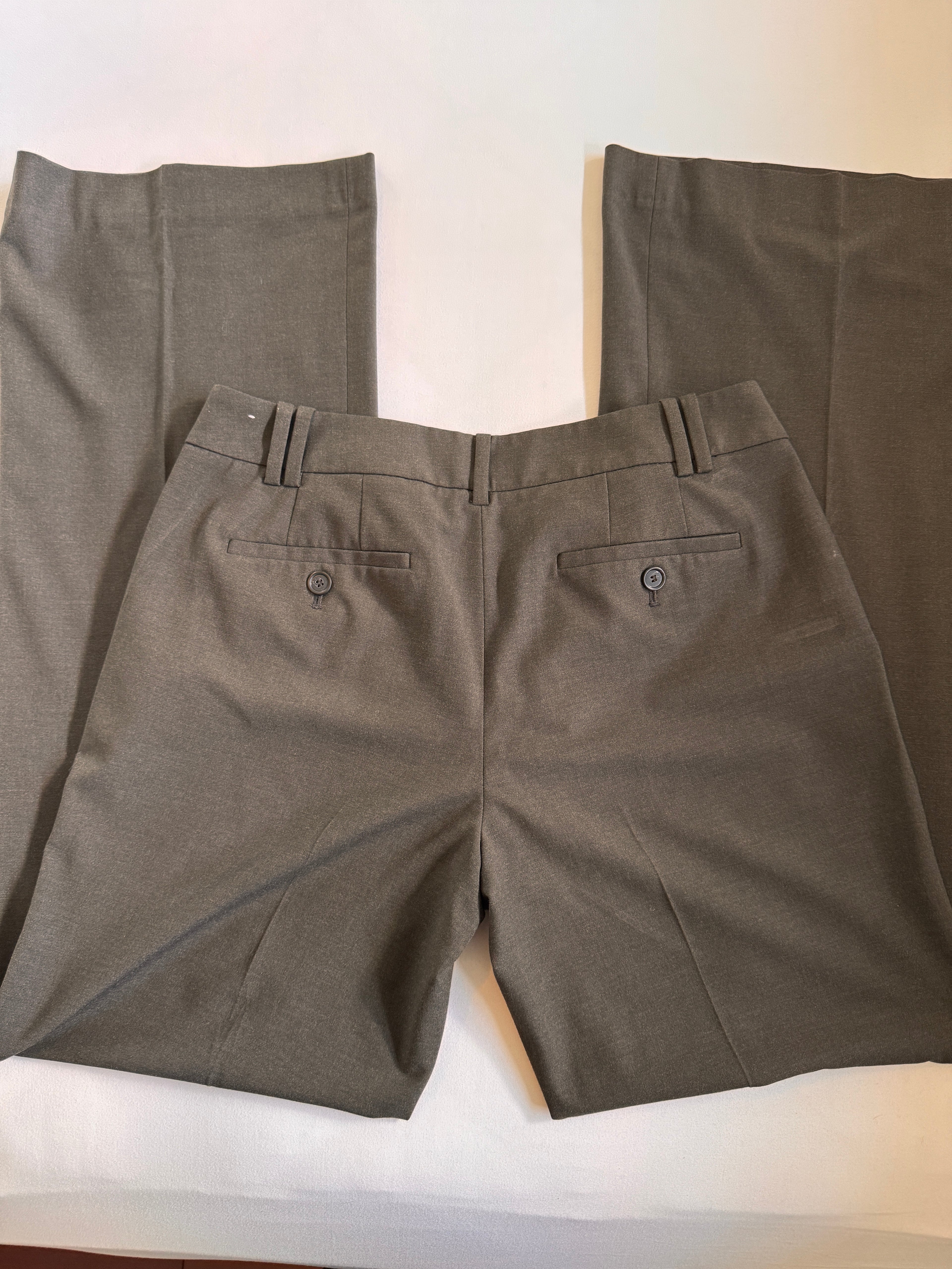 Folded dark gray pants on a white surface