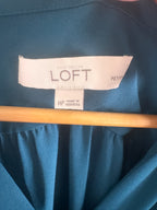 Blue fabric with a LOFT label on a wooden stick
