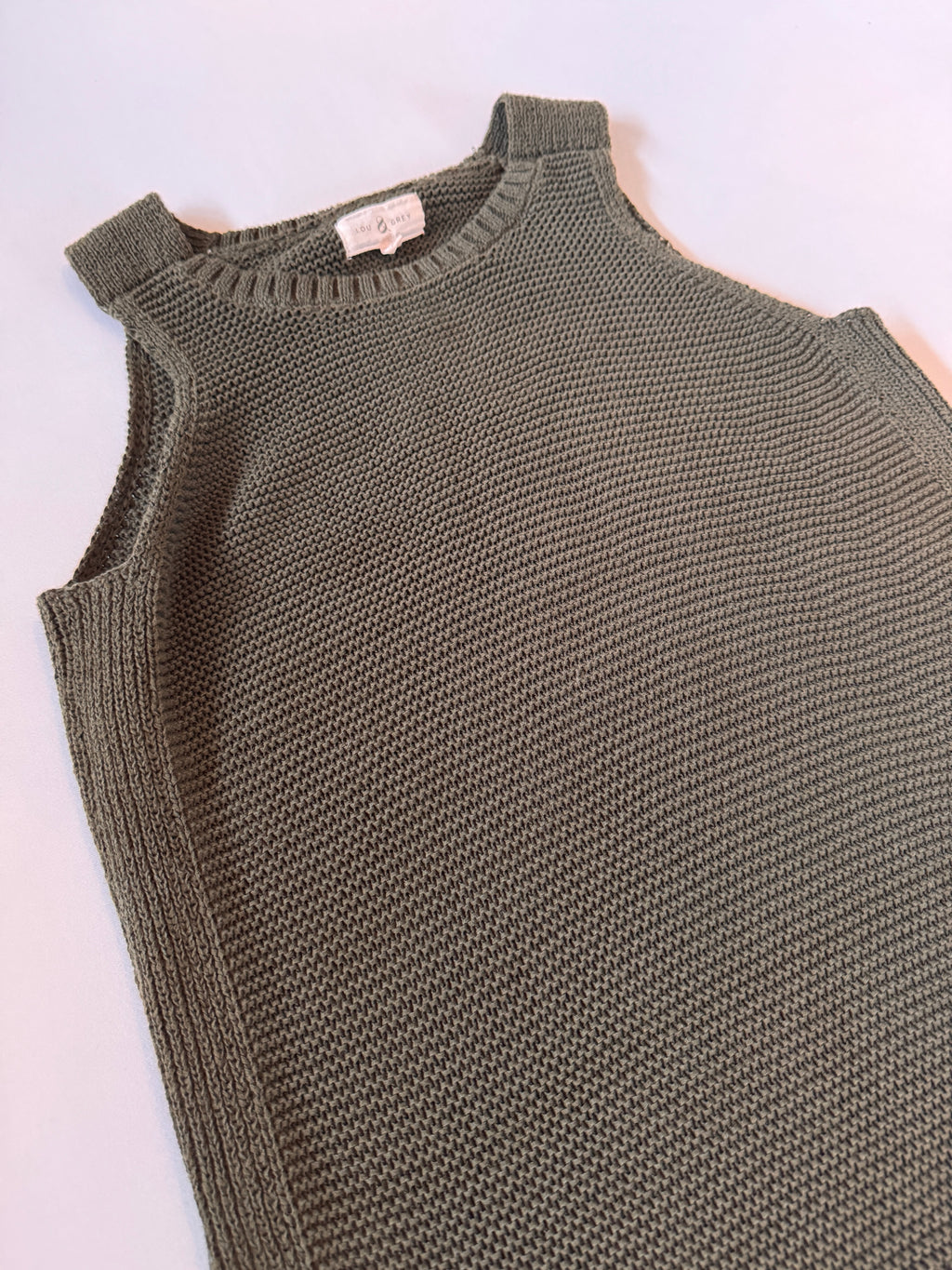 Green knitted tank top on a white background