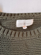 Close-up of a knitted fabric with a brand label on a plain background