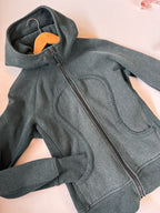 Green jacket on a hanger against a light pink background