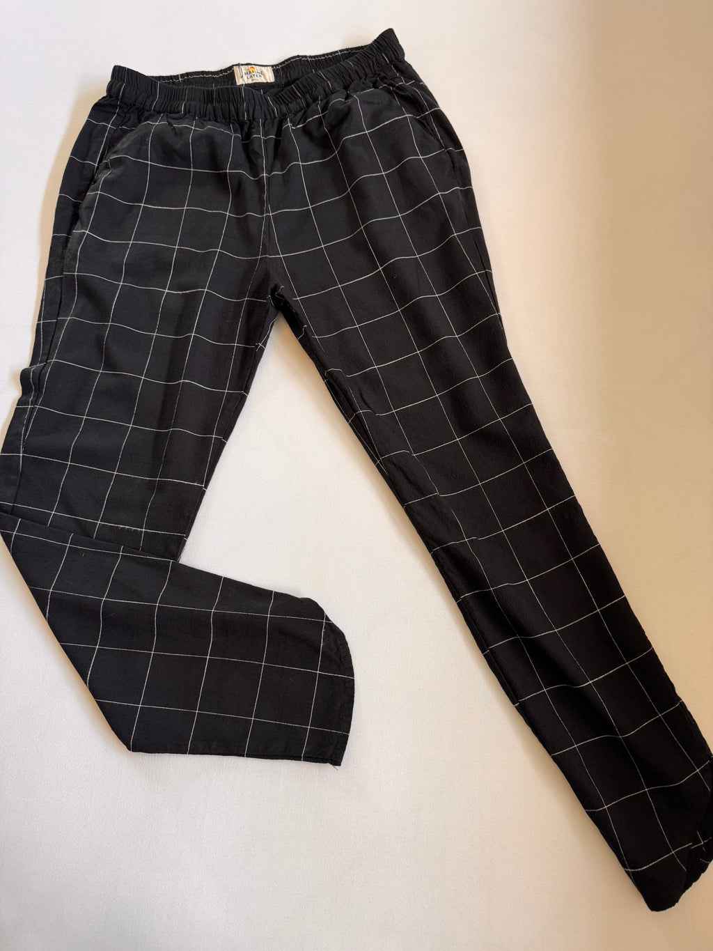Black checkered pants on a beige background