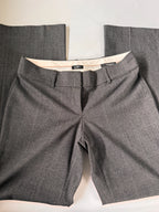 Gray suit pants with a white shirt underneath on a light background
