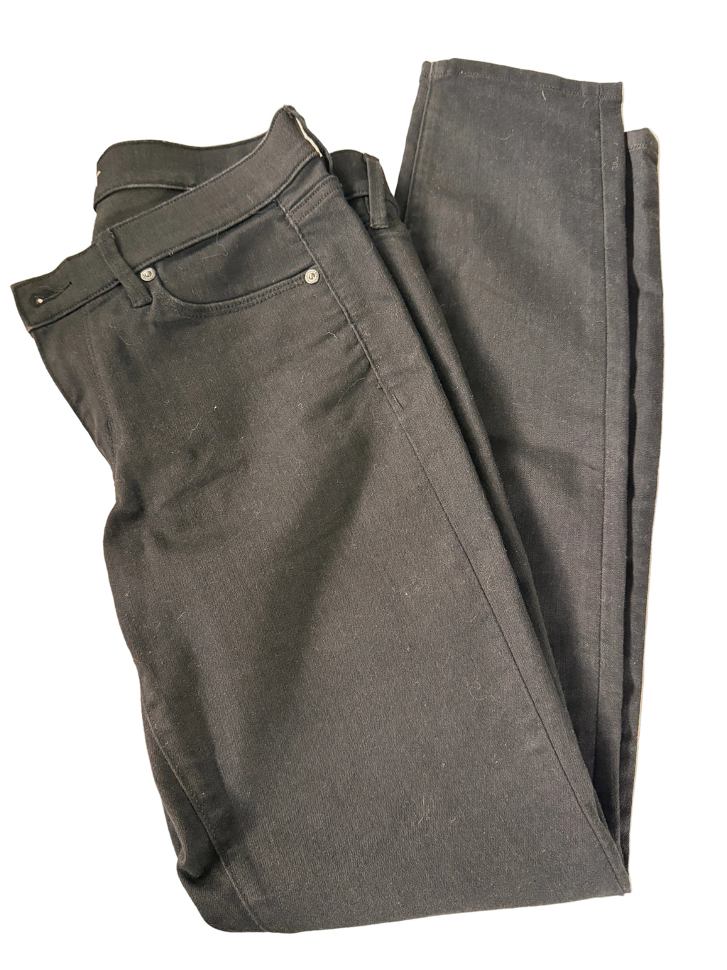 Folded black pants on a beige background