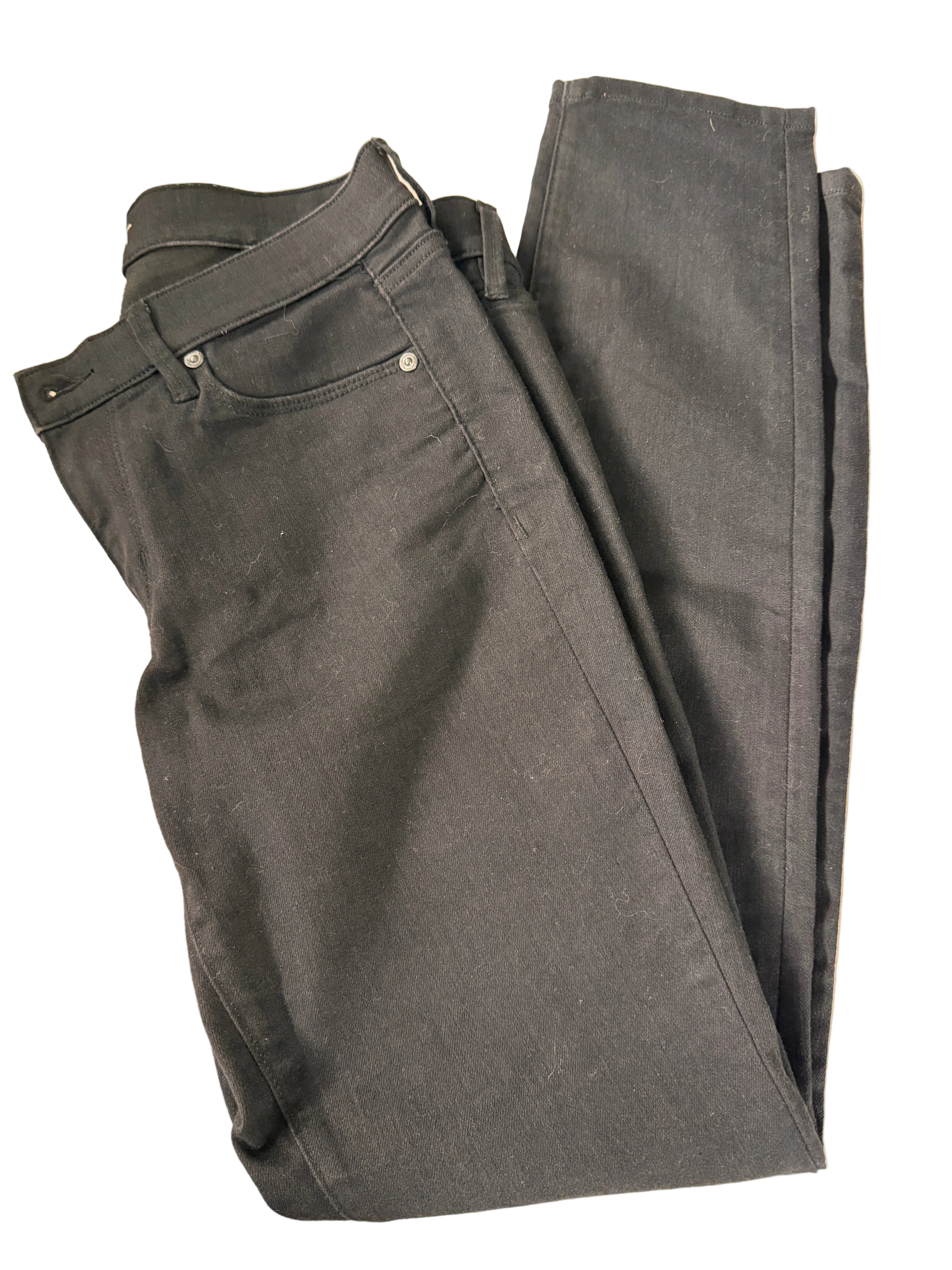 Folded black pants on a beige background