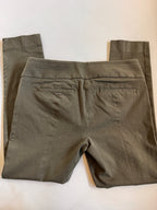 Folded green pants on a white surface