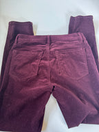 Folded maroon pants on a white background
