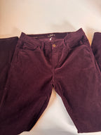 Folded maroon pants on a light beige surface