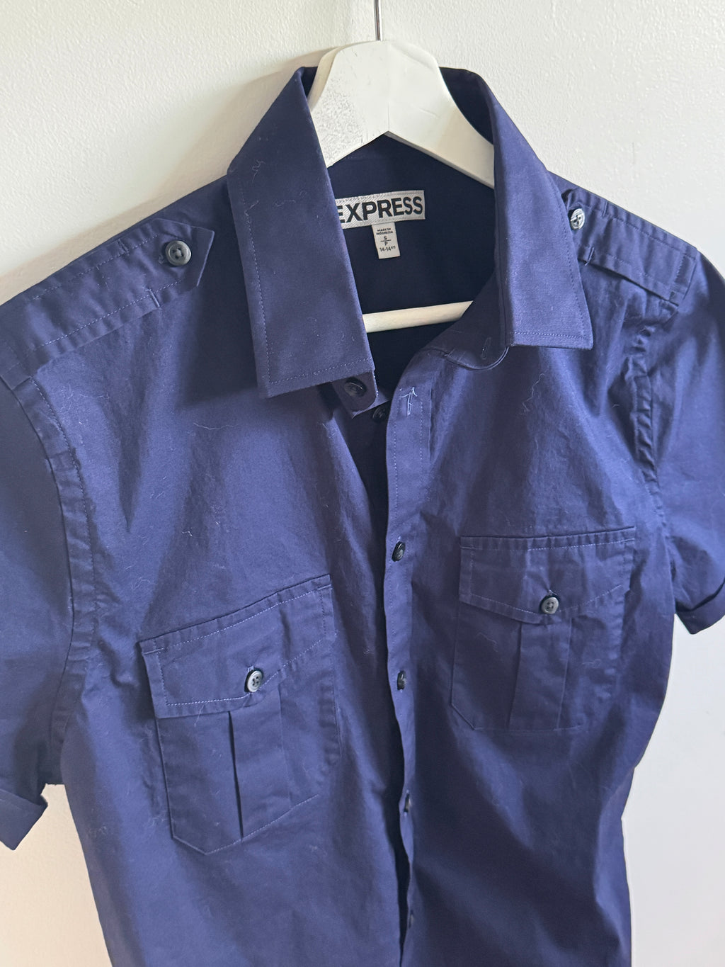 Blue shirt on a white surface with a visible Express tag.