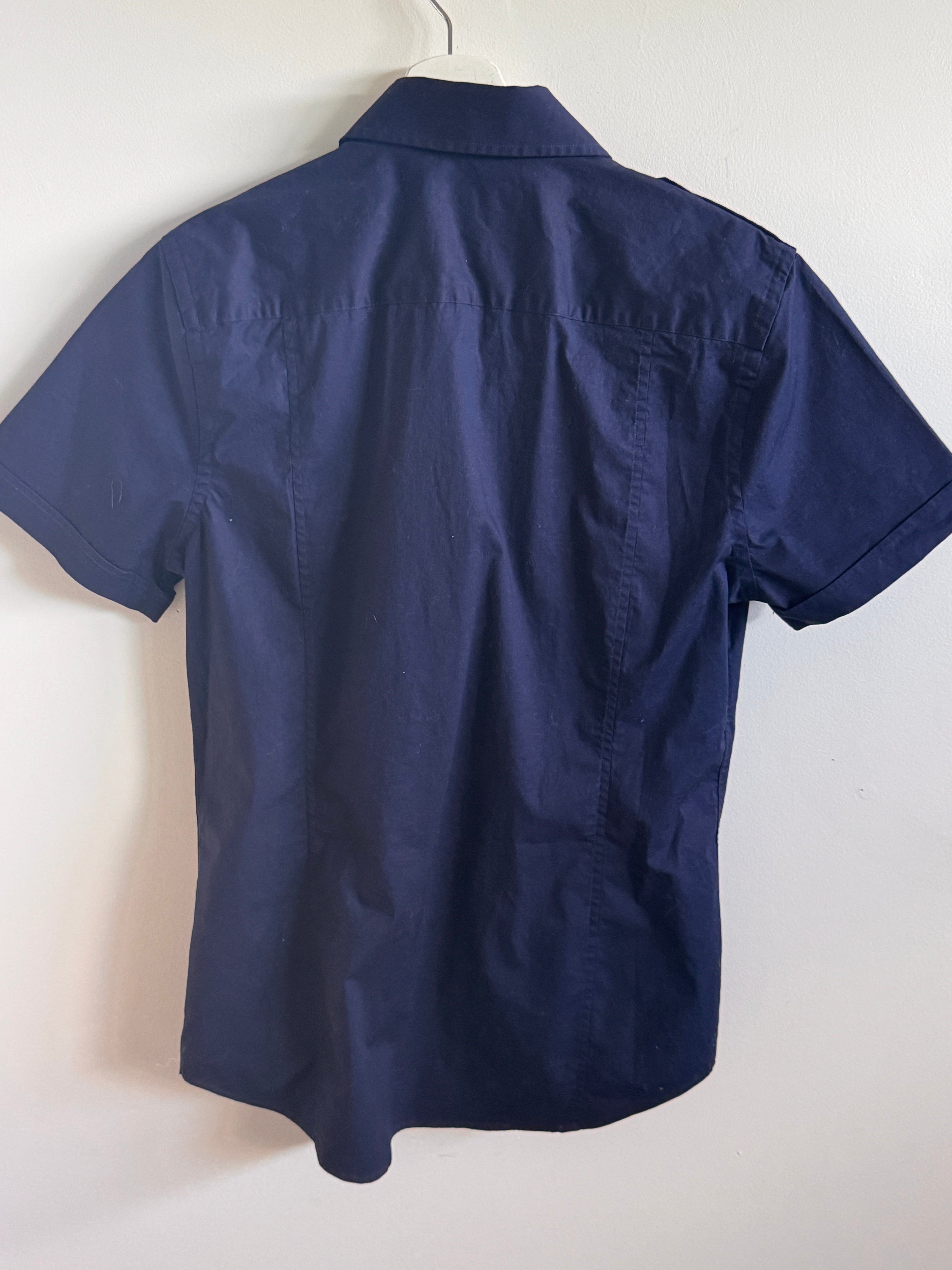 Navy blue short-sleeve shirt on a hanger against a white background