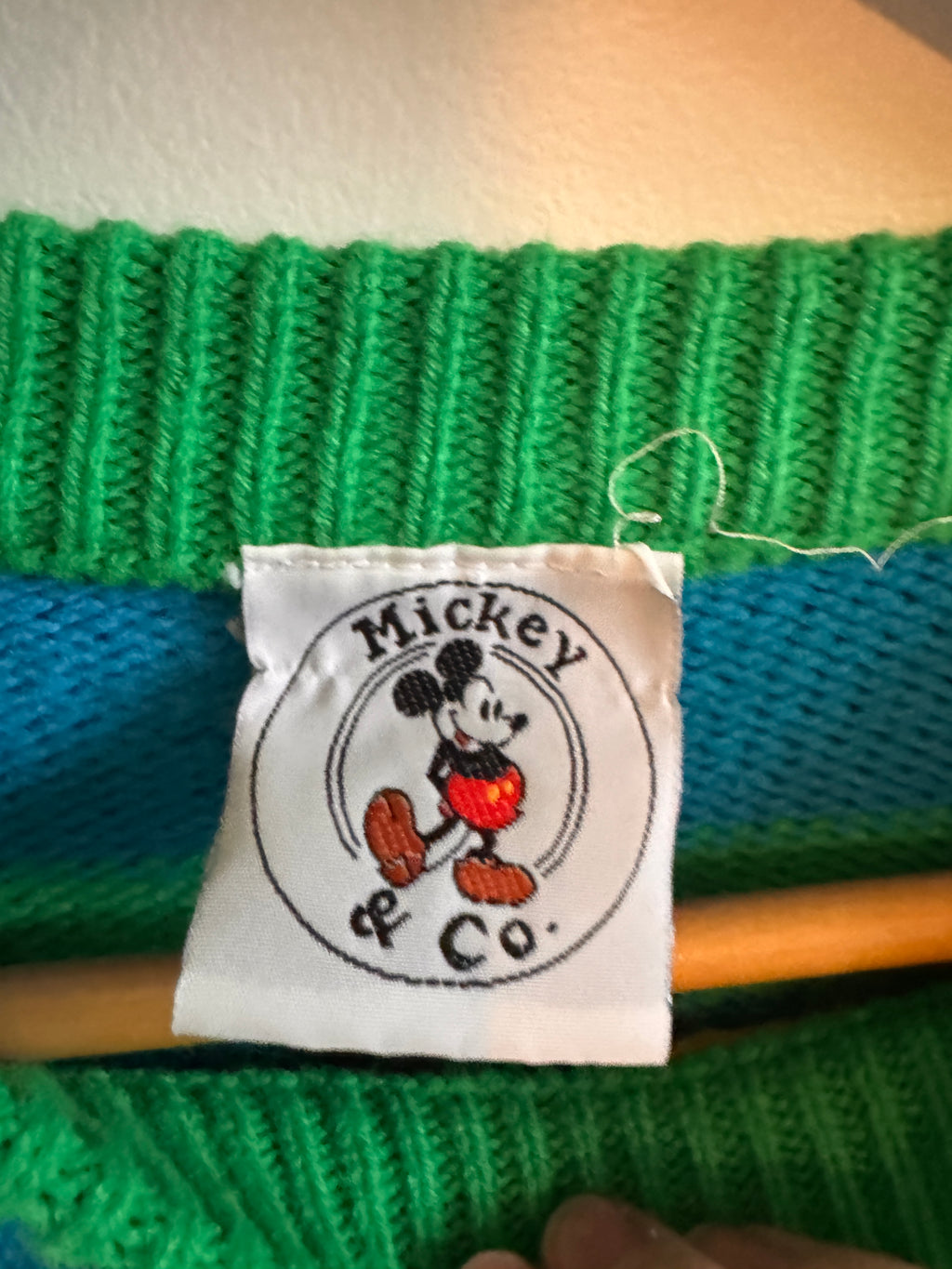 Close-up of a green knitted fabric with a Mickey & Co label.