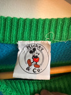 Close-up of a green knitted fabric with a Mickey & Co label.