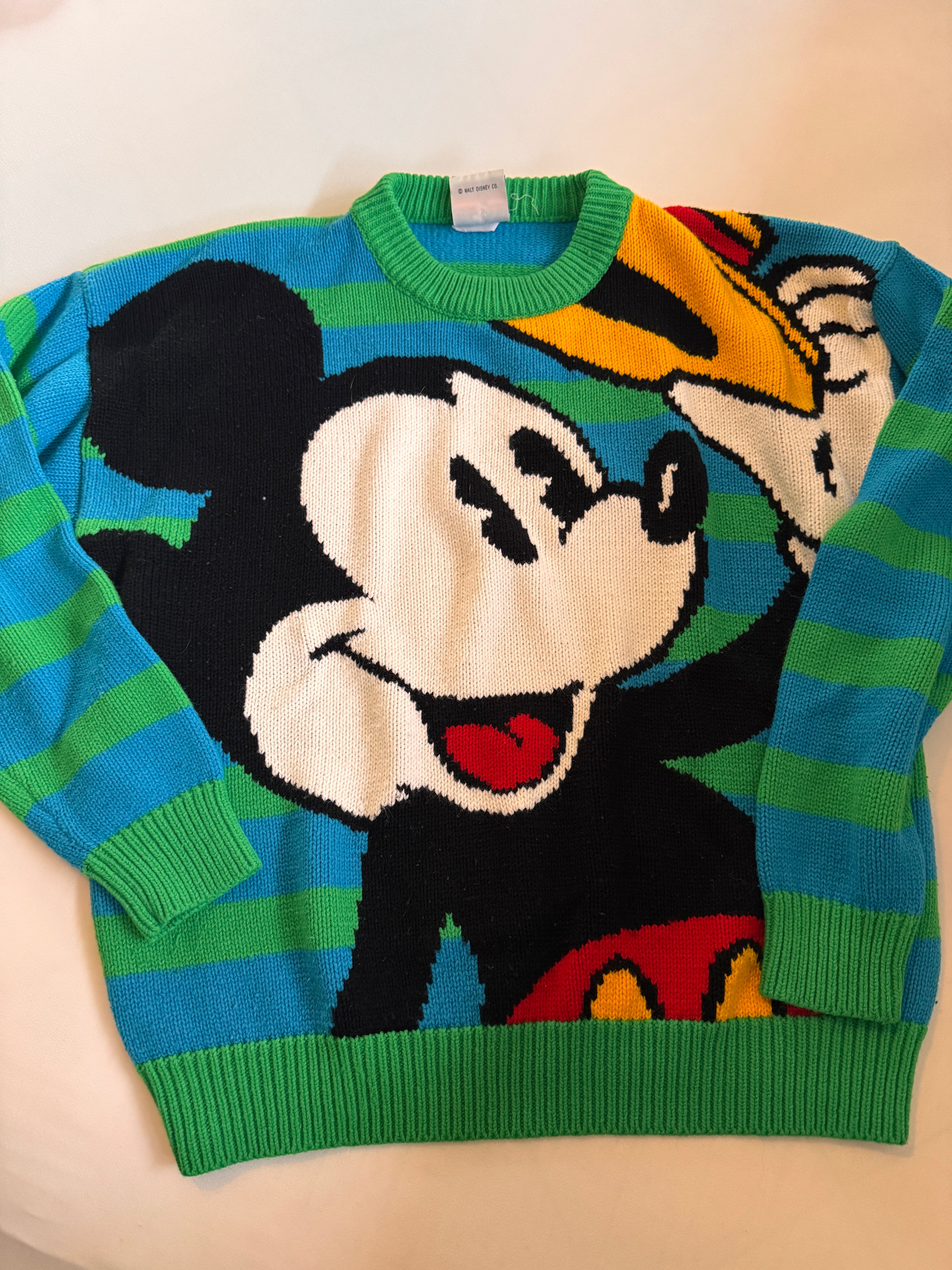 Colorful sweater with cartoon character design on a light background