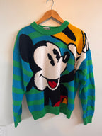 Colorful sweater with Mickey Mouse on a hanger against a plain background